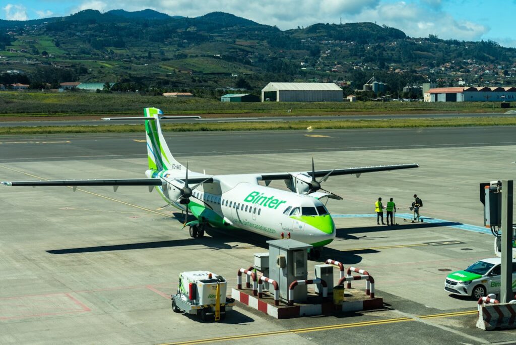 Binter ATR 72-600 plane on tarmac at Tenerife airport with mountainous backdrop.